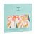 A boxed aden + anais boutique silky soft muslin dream blanket with a floral design in pink, orange, and blue, made from bamboo-infused viscose for extra comfort. The light blue packaging has product details in English and French.