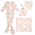 The aden + anais snuggle knit™ newborn gift set includes a floral-patterned outfit: a long-sleeve knotted gown, charming knotted baby hat, snap-closure bib, and blanket. All pieces feature white fabric with pink floral prints.