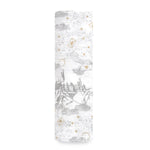 The aden + anais boutique iconic 100% cotton muslin swaddle blanket features rolled-up white fabric with subtle gray designs of castles, magical symbols, and flying creatures. Gold stars and crescent moons add whimsy, reminiscent of a Harry Potter™ adventure.