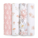 Four aden + anais organic cotton muslin swaddle blankets are displayed: pink with white leaves, white with mushrooms and flowers, white with large pink flowers, and white with small pink flowers. Each blanket is 100% organic muslin and GOTS certified for supreme quality.