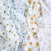 Close-up of crumpled white aden + anais organic cotton muslin swaddle blankets with fruit patterns: green pears on the left, blue blueberries with yellow lemons in the middle, and red cherries on the right. This playful design is perfect for sustainable baby products.