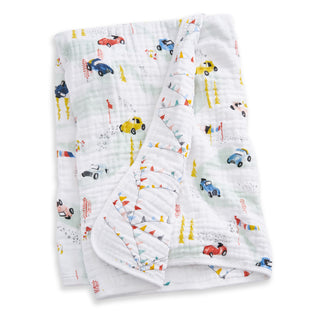 The aden + anais essentials cotton muslin dream blanket, made from soft cotton and featuring colorful cartoon cars, flags, and trees, is neatly folded to display part of its playful pattern.