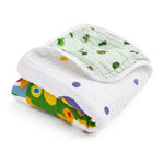The aden + anais essentials cotton muslin dream blanket is a soft, quilted baby blanket featuring colorful patterns like polka dots, animal faces, and a green side with turtle illustrations.