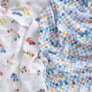 The aden + anais essentials cotton muslin swaddle blanket 2 pack includes two soft blankets: one with colorful cars, cones, and flags on white, and another with a vibrant blue, orange, and yellow checkered pattern.