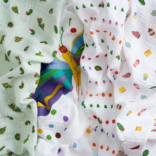 The aden + anais essentials cotton muslin swaddle blanket 4 pack – eric carle features soft, breathable blankets printed with The Very Hungry Caterpillar, butterfly, fruits, food, and polka dots on white and pale green backgrounds.