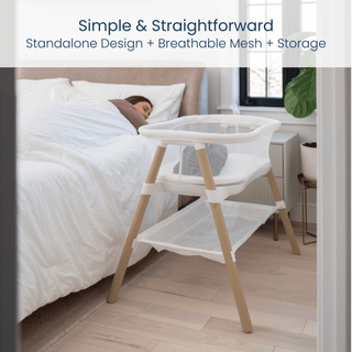 The HALO BassiNest® Essential Sleeper, featuring breathable mesh walls and a storage shelf, stands beside a bed where a woman sleeps. Text above reads: Simple & Straightforward: Standalone Design + Breathable Mesh + Storage.