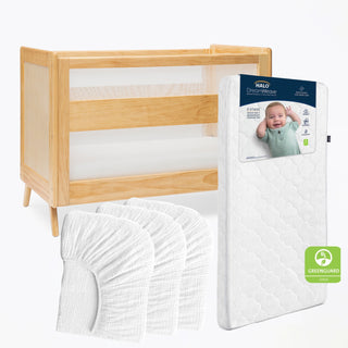 The HALO Breathable Nursery Bundle includes a light wood crib with mesh sides, a breathable crib mattress with baby on the box, four white muslin sheets, and features Greenguard Gold certification.