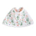 The aden + anais essentials cotton muslin burpy bib features a charming floral design with green leaves and pink flowers on absorbent white muslin. Its crafted for style and functionality, making it perfect for any nursery.