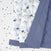 The aden + anais essentials cotton muslin bedding set 3 pack includes a quilt with a blue border, draping over a star-patterned surface. Ideal for a nursery, it features soft cotton adorned with owls, elephants, and turtles in calm blue and green hues.