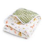 Introducing the aden + anais essentials cotton muslin dream blanket, featuring a cozy deer-and-rabbit print on white and a textured green reverse. Made from soft, absorbent cotton muslin with a charming white border.