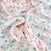 The aden + anais essentials cotton muslin dream blanket is soft and textured, featuring a floral pattern in pink, green, and white. Ideal for snuggling, it reveals crumpled sections of blooming flowers and leaves on a pastel background.