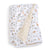 The aden + anais essentials cotton muslin dream blanket is a cozy, white baby blanket featuring a safari animal print with giraffes, elephants, and lions. The reverse side has beige polka dots. Its perfect for tummy time or cuddling and is displayed partially folded.