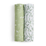 Two rolled viscose swaddles, part of the essentials silky soft swaddle blanket 2 pack by aden + anais, feature white ducks and plants on green beside a design of green leaves on white. These bamboo-infused fabrics are gentle for sensitive skin, ensuring comfort.