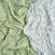 Two aden + anais essentials silky soft swaddle blankets are displayed: the left is light green with subtle white animal and plant patterns, and the right is white featuring bamboo-infused green leafy vine designs, ideal for sensitive skin. Both have a soft, crumpled texture reminiscent of viscose.