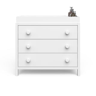 The Child Craft F01792 Universal Changing Table Topper in matte white sits atop a three-drawer dresser with round knobs, holding two bottles, all set against a plain white background.