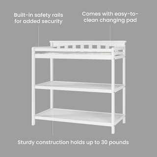 The Child Craft Flat Top Baby Changing Table in matte white features two lower shelves for nursery storage, built-in safety rails, baby-safe finishes, sturdy construction supporting up to 30 lbs, and an easy-to-clean pad.