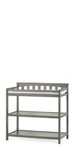 The Child Craft Flat Top Baby Changing Table in Dapper Gray features a slatted back rail, two open shelves for nursery storage, and a flat changing surface on top with a small white baby changing pad.