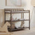 The Child Craft Flat Top Baby Changing Table in Dapper Gray features a baby changing pad and two shelves for nursery storage displaying a plush rabbit, blankets, books, and a teddy bear. A wooden rocking horse and floor lamp complete the softly lit room.