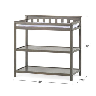 The Child Craft Flat Top Baby Changing Table in Dapper Gray features two open nursery storage shelves, a slatted back, and a white changing pad. Dimensions: 38"W x 19.5"D x 36"H.