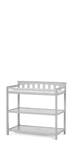The Child Craft Flat Top Baby Changing Table in Cool Gray features baby-safe finishes, two open nursery storage shelves, and a safety rail around the top surface.