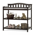 The Child Craft Arch Top Baby Changing Table in Jamocha is classic nursery furniture with a curved back, padded changing pad, and two shelves for towels, glass bottles, a teddy bear, decorative balls, and a wooden box.