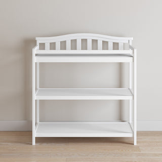 The Child Craft Arch Top Baby Changing Table in matte white features slatted sides, two open shelves, and a curved top backrest—perfect nursery furniture for organized storage and style.