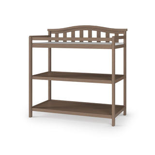 The Child Craft Arch Top Baby Changing Table in Dusty Heather features two open shelves and a curved slatted backrest, shown on a white background—an elegant and functional addition to any nursery.