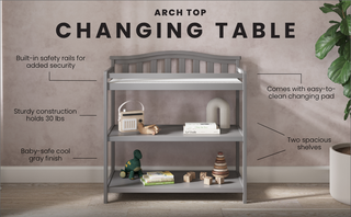 The Child Craft Arch Top Baby Changing Table in Cool Gray features a sturdy build, baby-safe finish, two spacious shelves, an easy-to-clean changing pad, safety rails, and comes with displayed baby items.