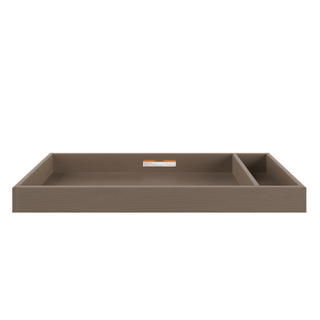The Child Craft F01792 Universal Changing Table Topper in Dusty Heather is a rectangular wooden tray with raised edges, a large main compartment, a smaller divided section, smooth surface for diaper changes, and a back-center label.