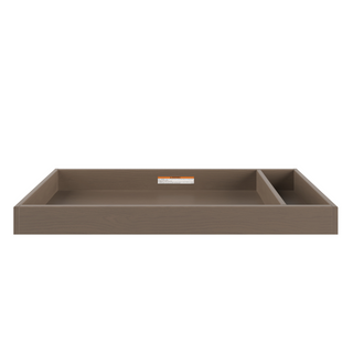 The Child Craft F01792 Universal Changing Table Topper in Dusty Heather is a rectangular wooden tray with raised edges, a large main compartment, a smaller divided section, smooth surface for diaper changes, and a back-center label.