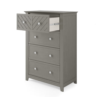The Child Craft Atwood 4-Drawer Chest in Lunar Gray features a chevron-patterned front, four drawers with round silver knobs, and a partially open top drawer.