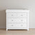 The Child Craft Atwood 3-Drawer Dresser in matte white features two top drawers with a chevron pattern and one larger plain drawer below, shown on a light wood floor against a beige wall.