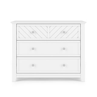 The Child Craft Atwood 3-Drawer Dresser in matte white features geometric patterns on the top drawer and round knobs, set against a white background.