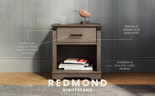 The Child Craft Redmond Nightstand in Dapper Gray features black metal pulls, a spacious drawer, an open shelf for books, and a rustic finish. The top holds a bird figurine and clock, blending style and storage beautifully.