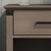 A close-up of the Child Craft Redmond Nightstand in Dapper Gray shows its drawer with a black handle, open shelf, and metal corner accents. A ribbed white object rests partially on top.