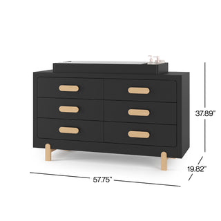 The Child Craft Legacy Changing Table Topper in Caviar Black sits on a black dresser with six drawers, light wood handles and legs, baby items on top. Dresser measures 57.75"W x 37.89"H x 19.82"D.
