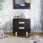 The Park Heights Night Stand in Caviar Black by Child Craft stands against a blue and white abstract wall, topped with decor, books, and candles. Children's books and a stuffed animal are placed on the wooden floor nearby.