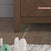 Close-up of the Child Craft Kieran 6-Drawer Double Dresser in Toasted Chestnut, featuring a copper handle, set on wooden flooring with part of a white textured rug and scattered wooden toys in the foreground.