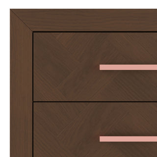 Close-up of the Child Craft Kieran 6-Drawer Double Dresser in Toasted Chestnut shows the herringbone corner detail and two drawers, each featuring a long, horizontal pink handle.