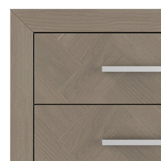 A close-up of the Child Craft Kieran 6-Drawer Double Dresser in Crescent Gray shows the top two drawers, featuring a light wood herringbone pattern and modern horizontal metal handles.