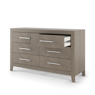 The Child Craft Kieran 6-Drawer Double Dresser in Crescent Gray features sleek horizontal metal handles, a subtle herringbone pattern, and a partially open top middle drawer.