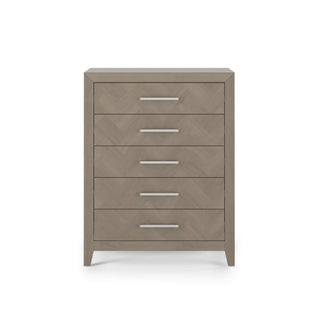 The Child Craft Kieran 5-Drawer Chest in Crescent Gray features a modern light wood design, sleek horizontal silver handles on each drawer, and stands on short angled legs against a plain white background.