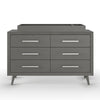 The Child Craft Universal Changing Table Topper F01792 in Lunar Gray is a modern accessory with silver handles and angled legs, designed to sit atop a six-drawer dresser and shown here against a white background.