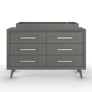 The Child Craft Cranbrook Double Dresser in Lunar Gray features six drawers, slender silver handles, angled legs, and an elevated tray on the back right—modern nursery furniture shown against a white background.