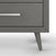 Close-up of the Child Craft Cranbrook Double Dresser in Lunar Gray, a mid-century modern piece with silver handles and angled legs—ideal for stylish nursery storage—set against a crisp white background.
