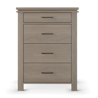 The Child Craft Denman 4 Drawer Chest in Crescent Gray features four drawers with sleek black handles and stands on four short legs, shown against a white background.