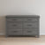 The Child Craft Denman Double Dresser in Midnight Gray, featuring six drawers with black handles, is placed against a plain light-colored wall on a light wood floor.