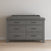 The Child Craft Denman Double Dresser in Midnight Gray with six drawers and black handles stands on a wooden floor against a light wall, topped with a matching Midnight Gray changing tray.