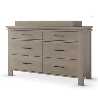 The Child Craft Denman Double Dresser in Crescent Gray features six drawers with black metal handles, a raised back panel, and a light gray finish, shown against a white background.