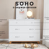 The Child Craft Soho 3-Drawer Dresser in White/Natural features spacious drawers, conical knobs, metal pulls, and a mid-century modern design with angled legs. A lamp and framed art are displayed on top against the wall.